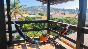 Uma rede em uma varanda com vista para a paisagem urbana.