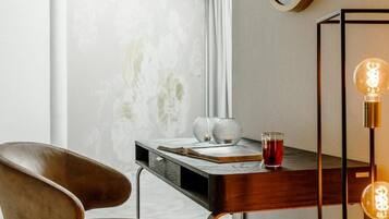 Una habitación moderna con un escritorio de madera, una silla de cuero y un aplique de pared.