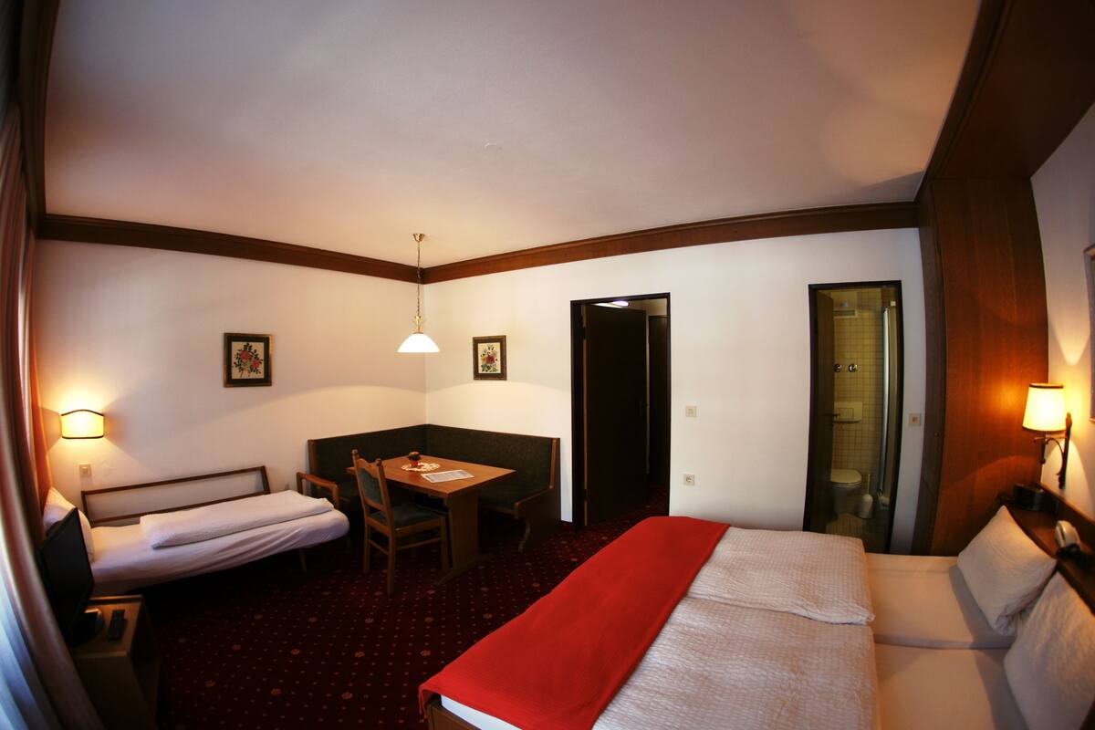 Une chambre d’hôtel comprenant un lit, un bureau, une chaise, une table et un miroir.