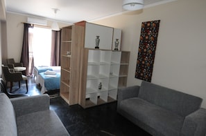 A modern living room with a sofa, a coffee table, and a bookshelf.