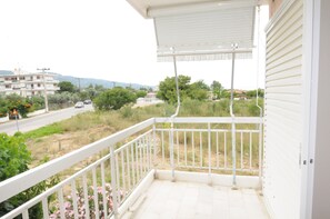 A balcony with a view of a road and buildings. - Kinetta Apartments (Oropos)
