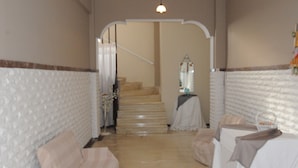 A hotel room with a staircase, a white textured wall, and a bed with a white cover. - Kinetta Apartments (Oropos)