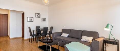 A modern living room with a sofa, coffee table, and dining area.