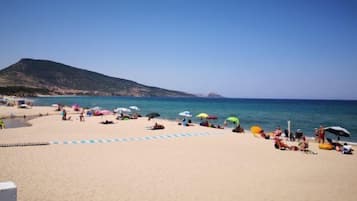 Una playa cerca, sillas reclinables de playa, sombrillas