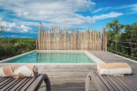 Una piscina al aire libre, sillones reclinables de piscina
