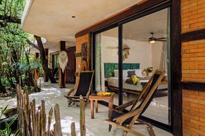 A room with a bed, a table with a fruit plate, and a chair. - Sunset Tulum (Tulum)