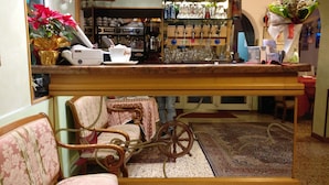 A bar area with a coffee machine, glassware, and a vintage bicycle wheel. - Hotel Fabrizio (Caorle)
