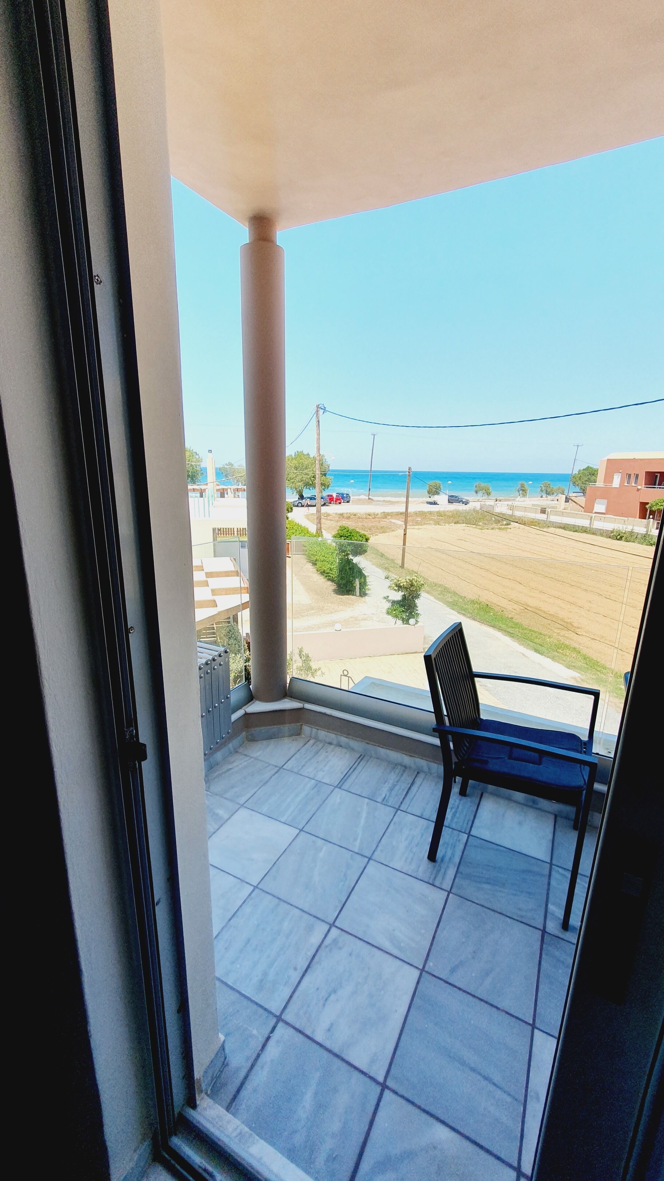A balcony with a view of a beach and buildings.