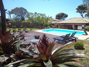 Alberca al aire libre y camastros 