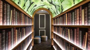 A library with bookshelves on both sides and a central aisle.