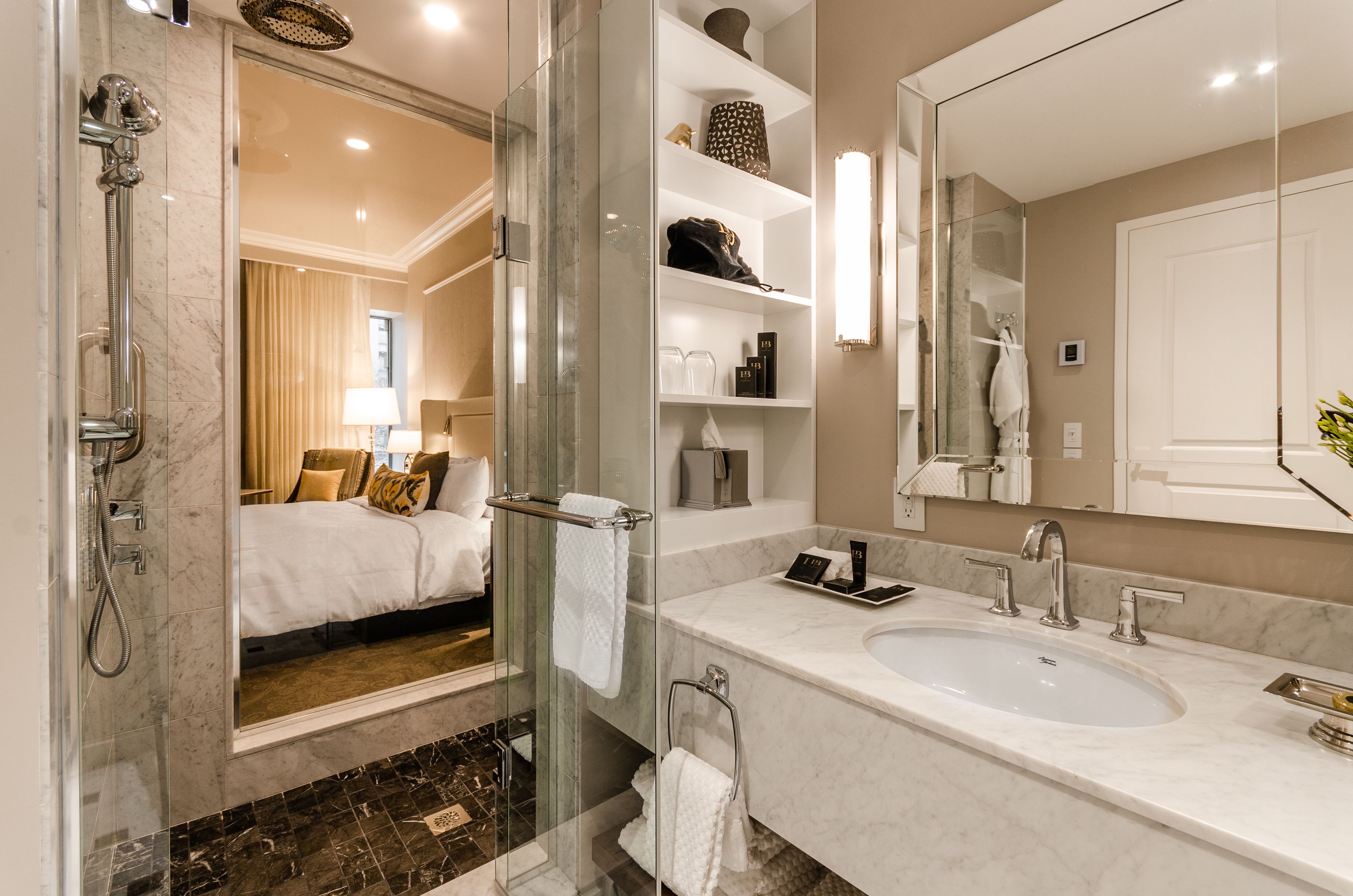 Casa de banho moderna com um espelho grande, chuveiro, lavatório e closet envidraçado.