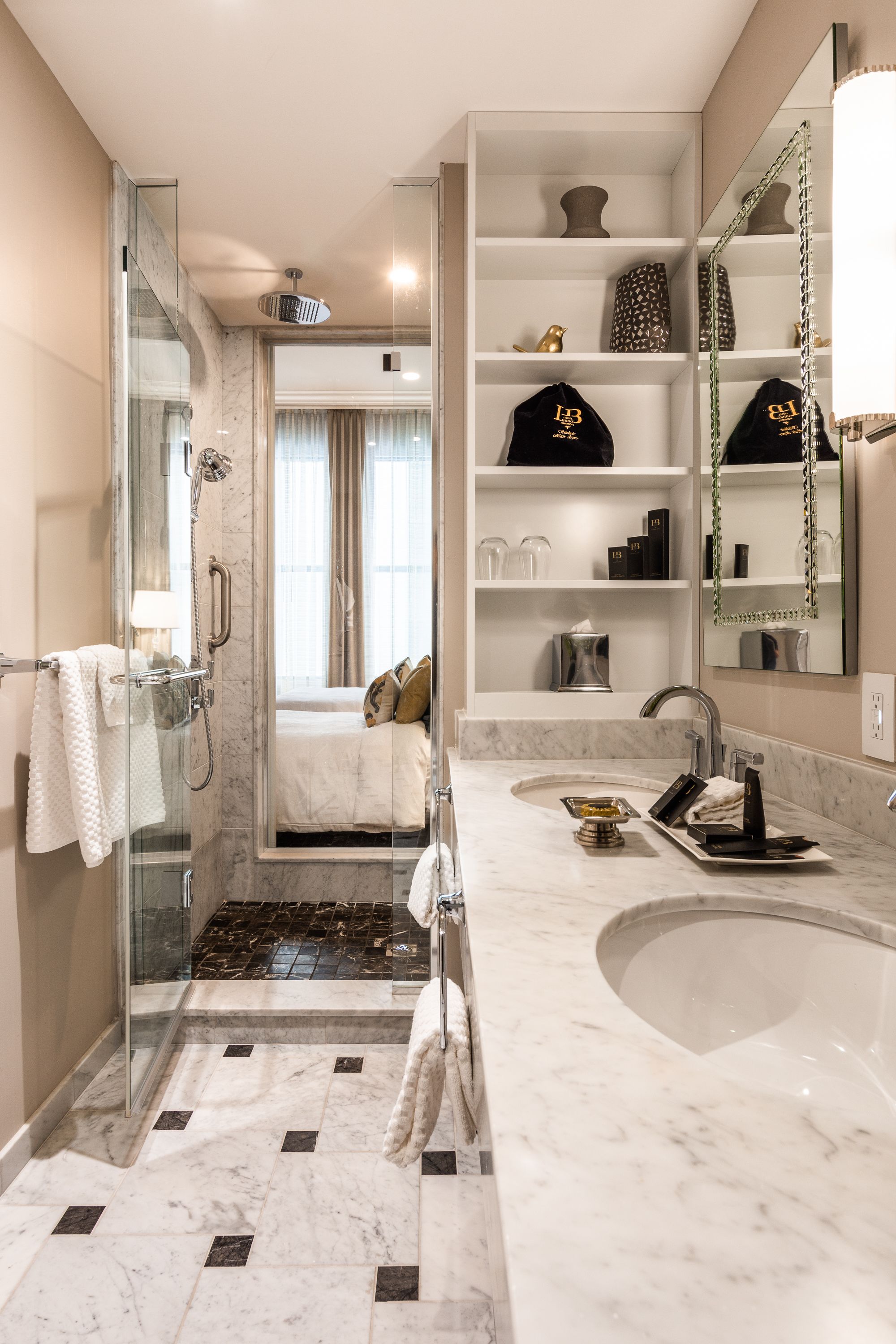 A modern bathroom with a glass-enclosed shower, a large mirror, and a vanity with a sink.
