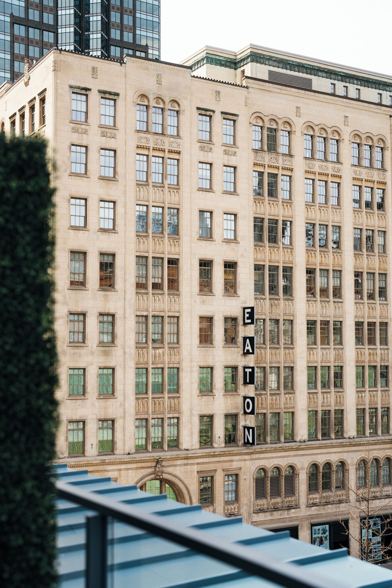 A multi-story building with a classic architectural style, featuring numerous windows and a prominent sign spelling "EATON" on the facade.