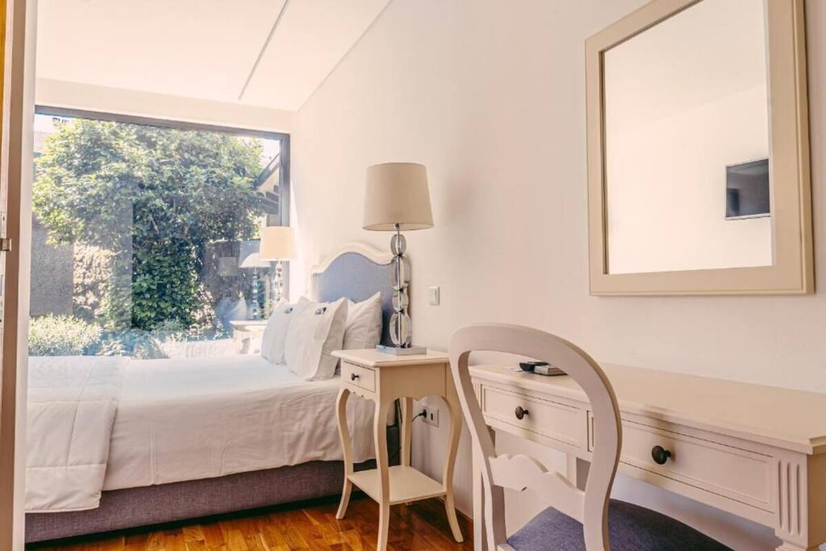 Un dormitorio con cama, mesita de noche, lámpara, cómoda y un espejo grande.