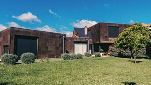 Un bâtiment moderne doté de grandes portes de garage, d’un toit en pente et d’une pelouse bien entretenue agrémentée de petits arbustes.