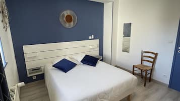 Une chambre à coucher avec un lit, une chaise, une horloge murale et un luminaire au plafond.