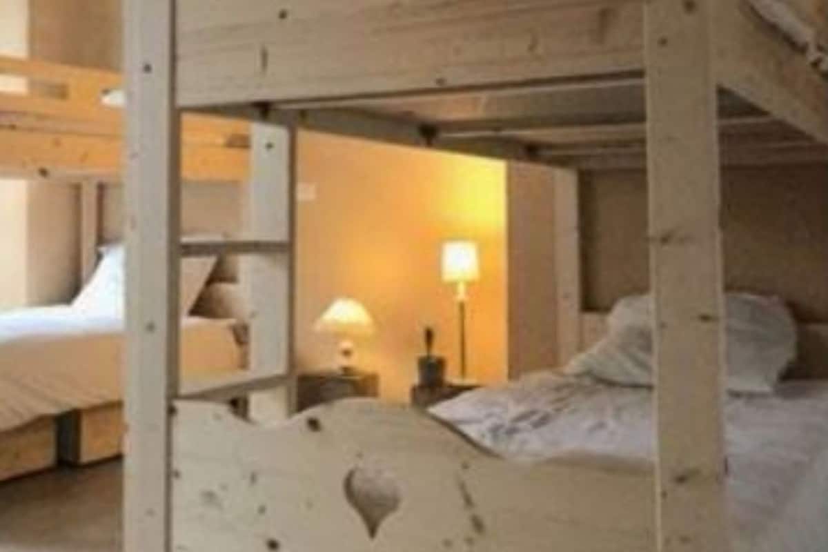 A rustic wooden room with a bunk bed and a single bed.