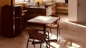 Una cocina moderna con una isla central, un comedor con dos sillas y un ventanal que proporciona luz natural.