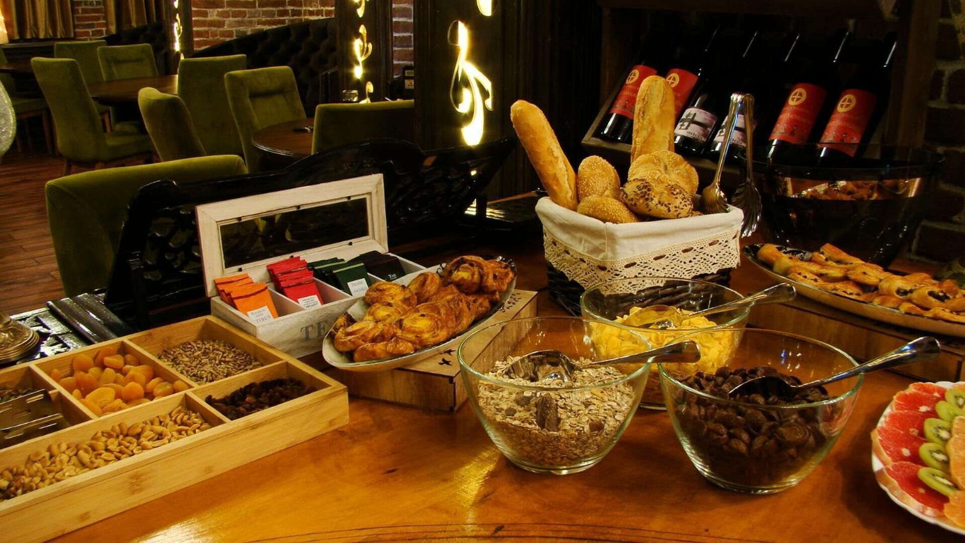 A buffet table with various food items including pastries, fruits, and nuts.