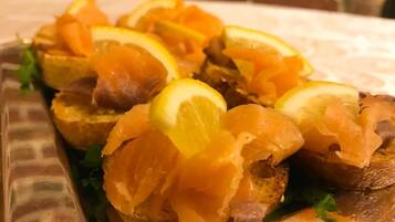 Un piatto con pane, salmone e fettine di limone.