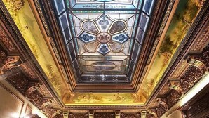 An ornate room with a stained glass ceiling, detailed woodwork, and a central chandelier. - Hotel Boutique 5 Continents (Craiova)