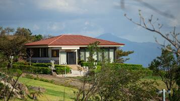 A modern house with a red roof, large windows, and a well-maintained garden.
