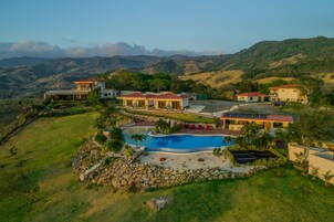 Uma propriedade extensa com várias casas, piscina e gramado bem cuidado.
