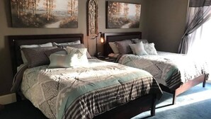A bedroom with two beds, each with a headboard, a nightstand, and a wall-mounted lamp. - Evans Holly Grove Inn B&B (Burlington)