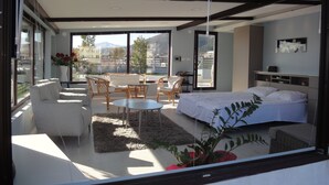 Une chambre moderne avec un grand lit, un canapé et un coin repas.