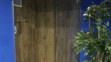Een moderne badkamer met houten wanden en een glazen deur.