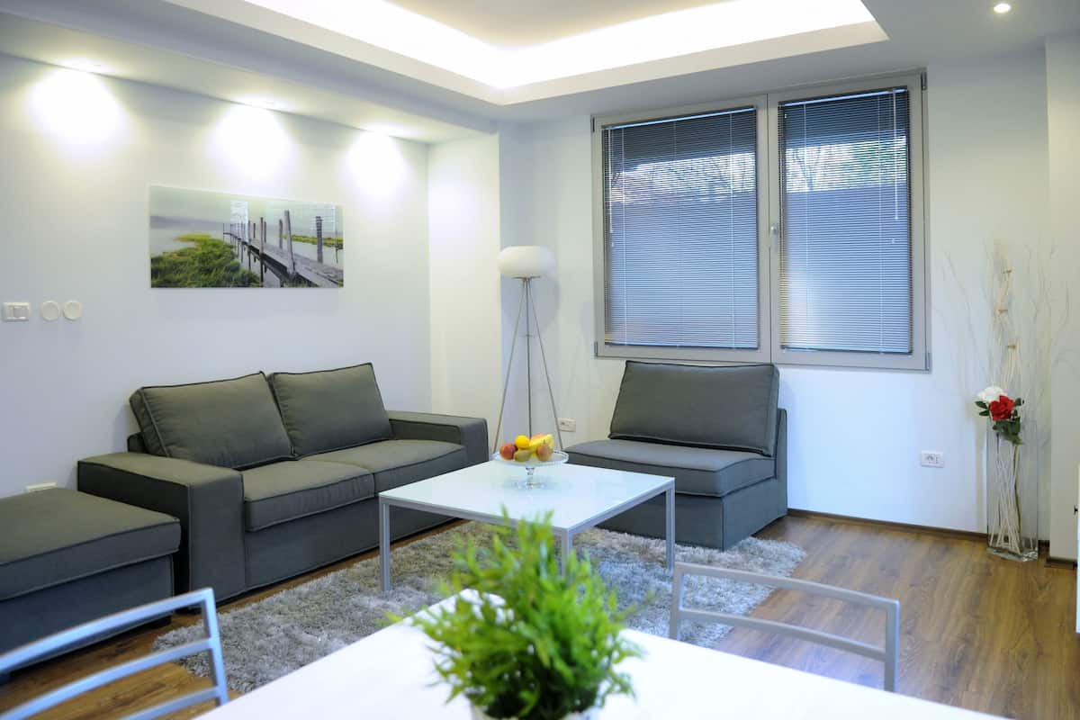 A modern living room with a grey sofa, a white coffee table, and a floor lamp.