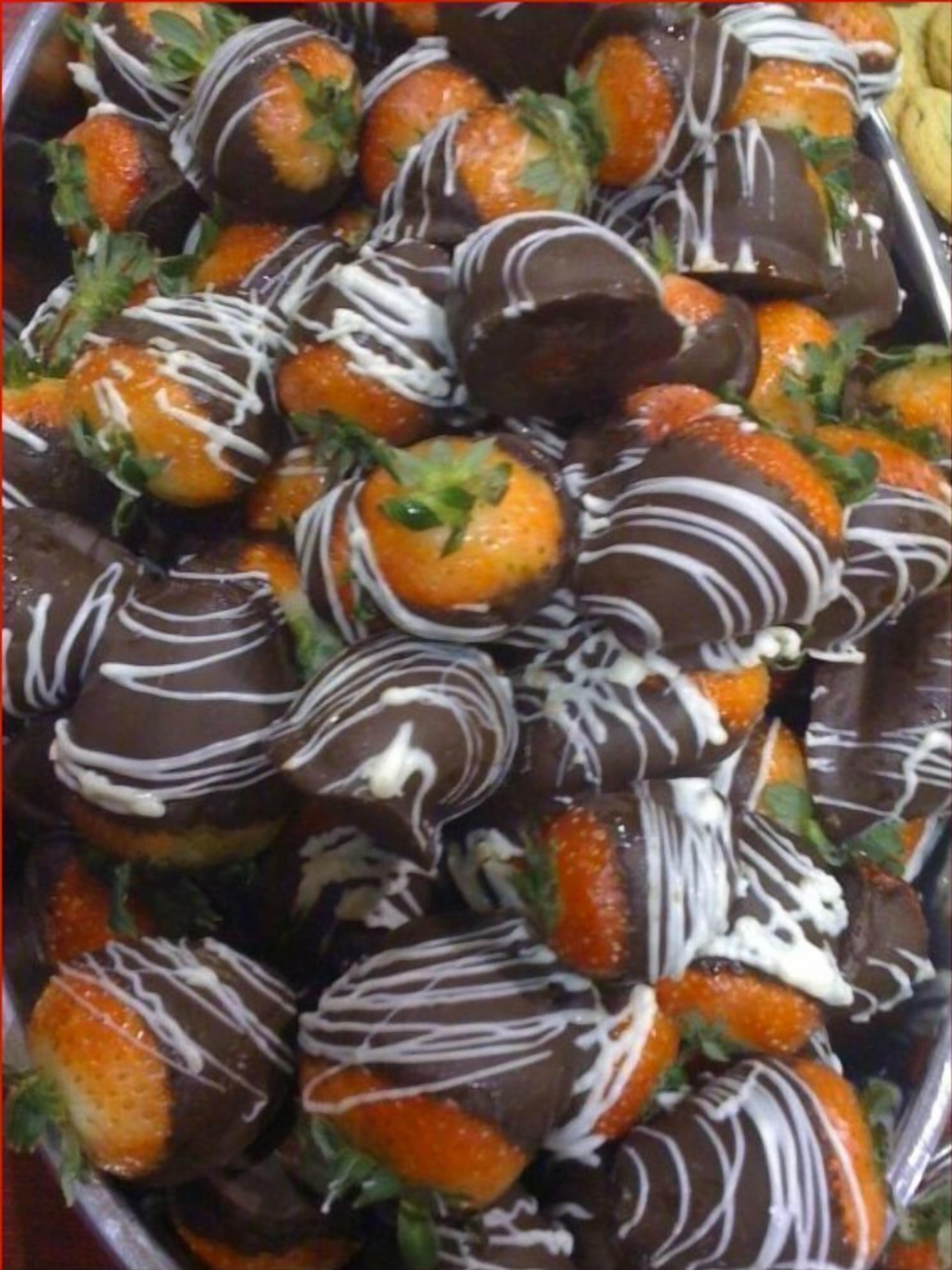 A tray of strawberries dipped in chocolate.