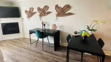 A dining area with a black table, teal chairs, and decorative wall art.