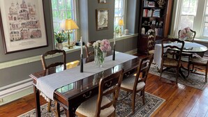 A dining area with a wooden table, chairs, and a chandelier. There are bookshelves and a framed picture on the wall. - Hargrave House B & B (Doylestown)
