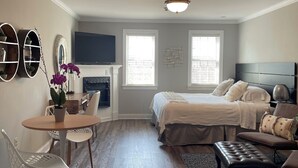 A bedroom with a bed, bedside table, and a seating area with a chair and ottoman. - Hargrave House B & B (Doylestown)