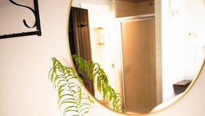 Une commode en bois avec un miroir, une plante et un livre.