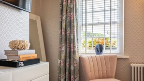 A room with a white desk, a chair, a radiator, and a window with blinds. - Georgian House Hotel (Whitehaven)