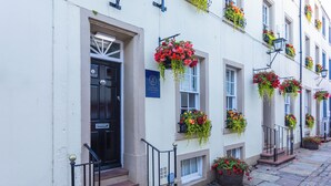 A row of white buildings with black doors, each with a sign indicating a Georgian House Hotel. - Georgian House Hotel (Whitehaven)