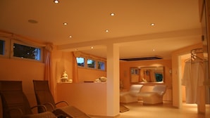 Une salle de spa équipée de fauteuils de massage, d’un comptoir d’accueil et d’un miroir.