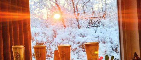 A bar with four beer taps and a window with a snowy view.
