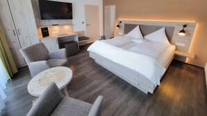Une chambre d’hôtel moderne dotée d’un grand lit, d’un bureau, d’une télévision et d’un coin salon.