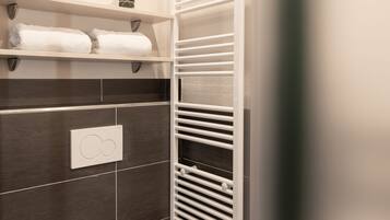 Et badeværelse med toilet, håndklædeholder og radiator.