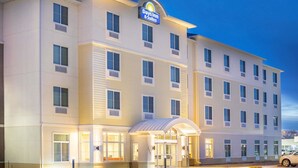 Un hotel Days Inn & Suites con una fachada moderna, múltiples ventanas y una entrada bien iluminada.