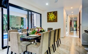 Enjoy meals in a beautifully set dining area with a large window offering a view of lush greenery.