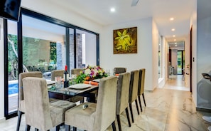 Enjoy meals in a beautifully set dining area with a large window offering a view of lush greenery.