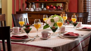 A breakfast table set with plates, glasses, and a variety of breakfast items including fruit and beverages. - The Buckingham Inn (Madison)