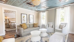 A living room with a sofa, two armchairs, a coffee table, and a patterned rug.