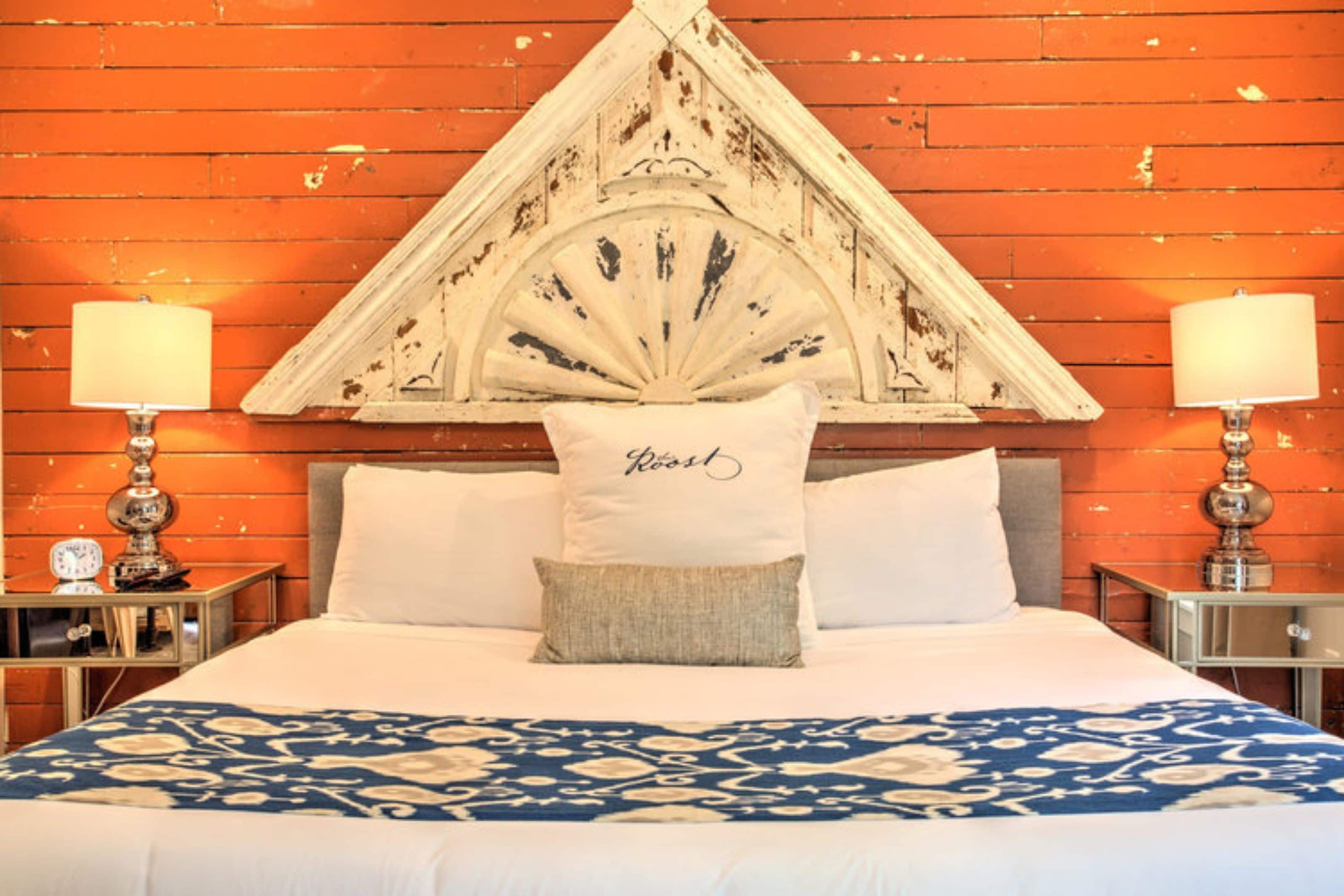 A bed with a decorative headboard, two bedside tables with lamps, and a patterned bedspread.