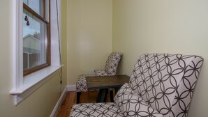 Une pièce d’angle avec une fenêtre, une chaise et une petite table.