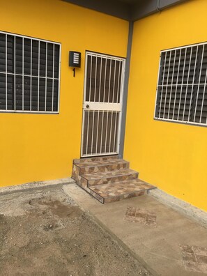Steps lead up to the entrance of this charming building with metal-barred windows.